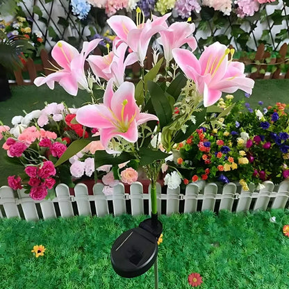Pink lily stake lights in front of a white picket fence — Casa Norex