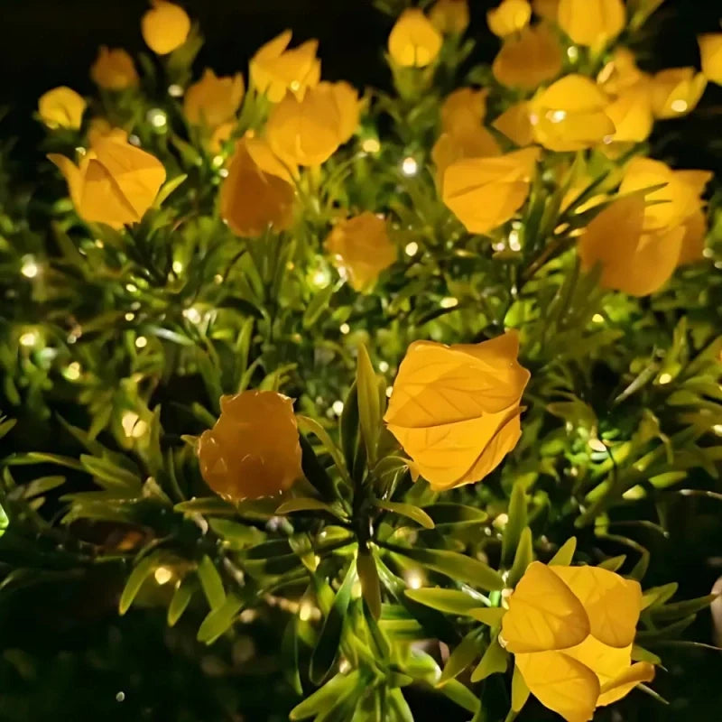 Yellow peony stake lights glowing among garden greenery — Casa Norex