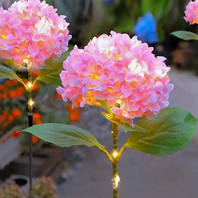 Close view of a large pink hydrangea stake light with a warm glow — Casa Norex