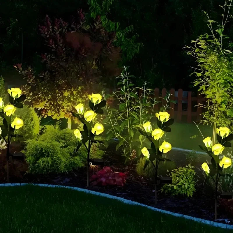 Yellow flower stake lights glowing in a dark garden border — Casa Norex