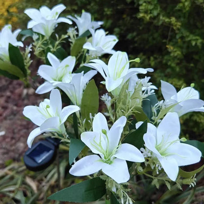 White lily stake lights with a solar panel on the ground — Casa Norex