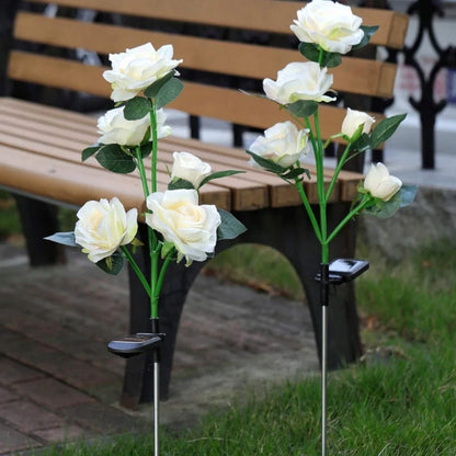 White rose stake lights beside a park bench at dusk — Casa Norex