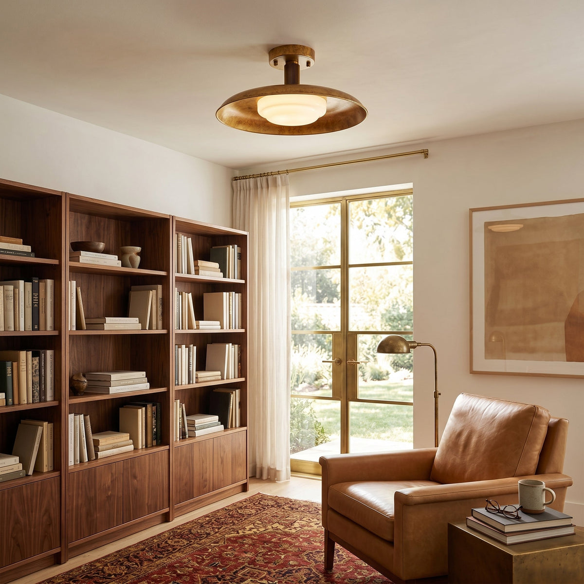 Gilded iron ceiling light in a library with a leather armchair — Casa Norex
