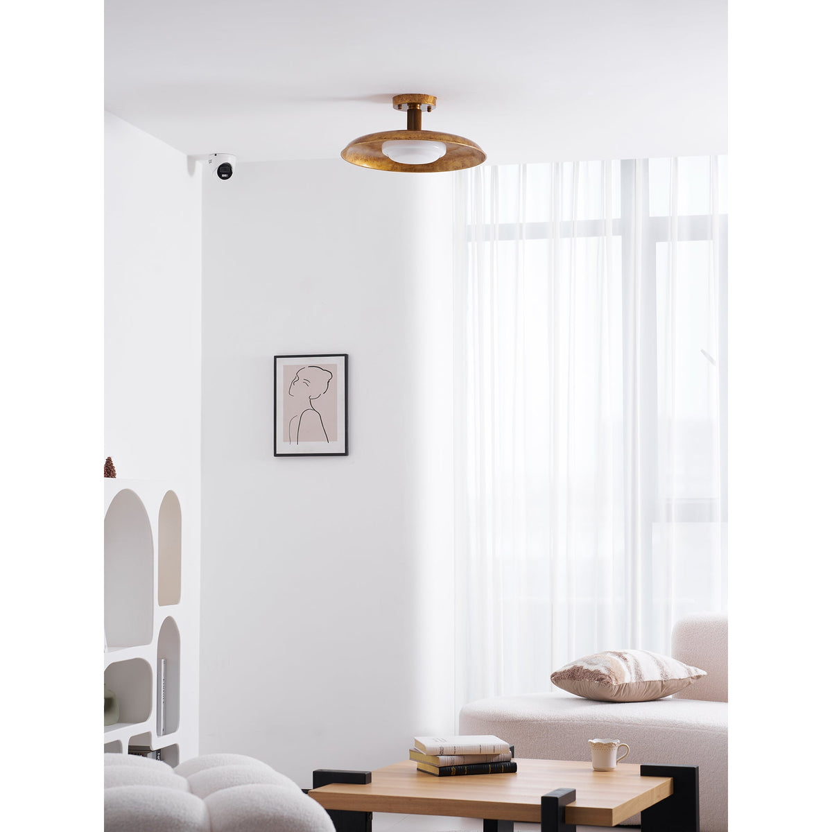 Gilded iron ceiling light in a white living room with a sofa — Casa Norex