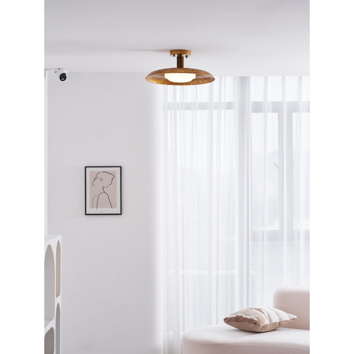 Gilded iron ceiling light in a white room with a framed print — Casa Norex