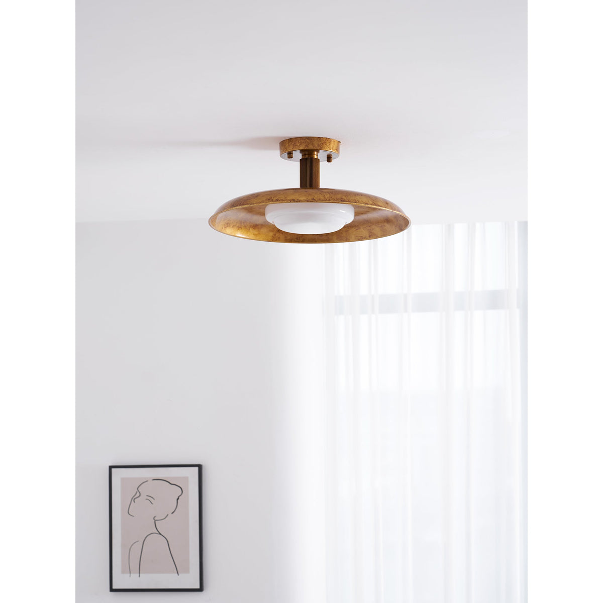 Gilded iron ceiling light in a bright room beside a framed picture — Casa Norex