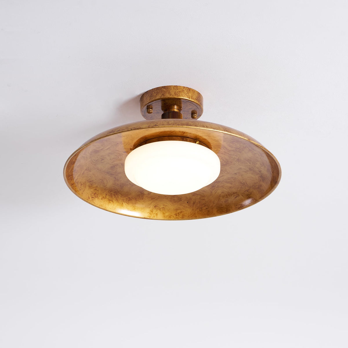 Gilded iron flush mount ceiling light lit from below — Casa Norex