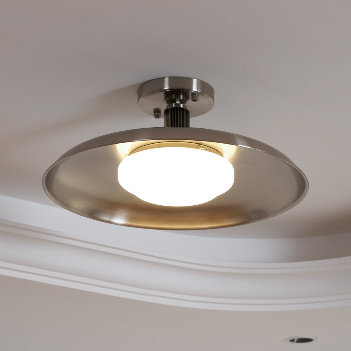 Polished nickel ceiling light with the glass diffuser lit — Casa Norex