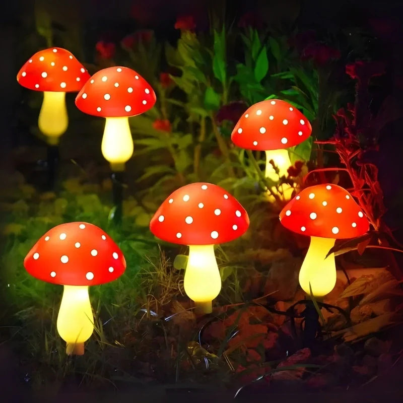 Red solar mushroom lights glowing in a garden border at night — Casa Norex