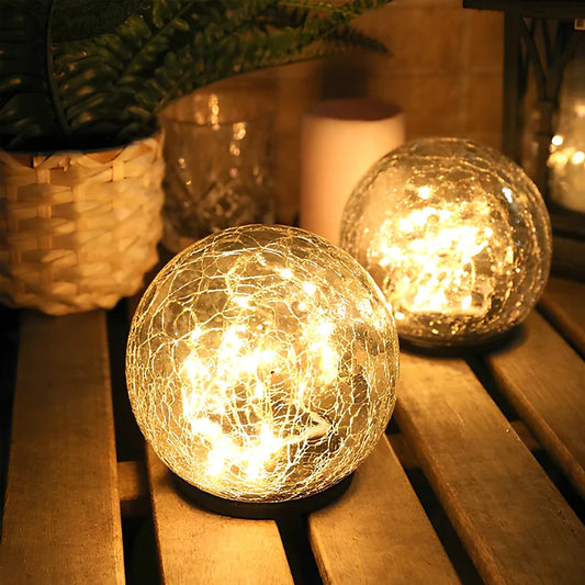 Cracked glass solar globe on a wooden bench in an outdoor setting | Casa Norex