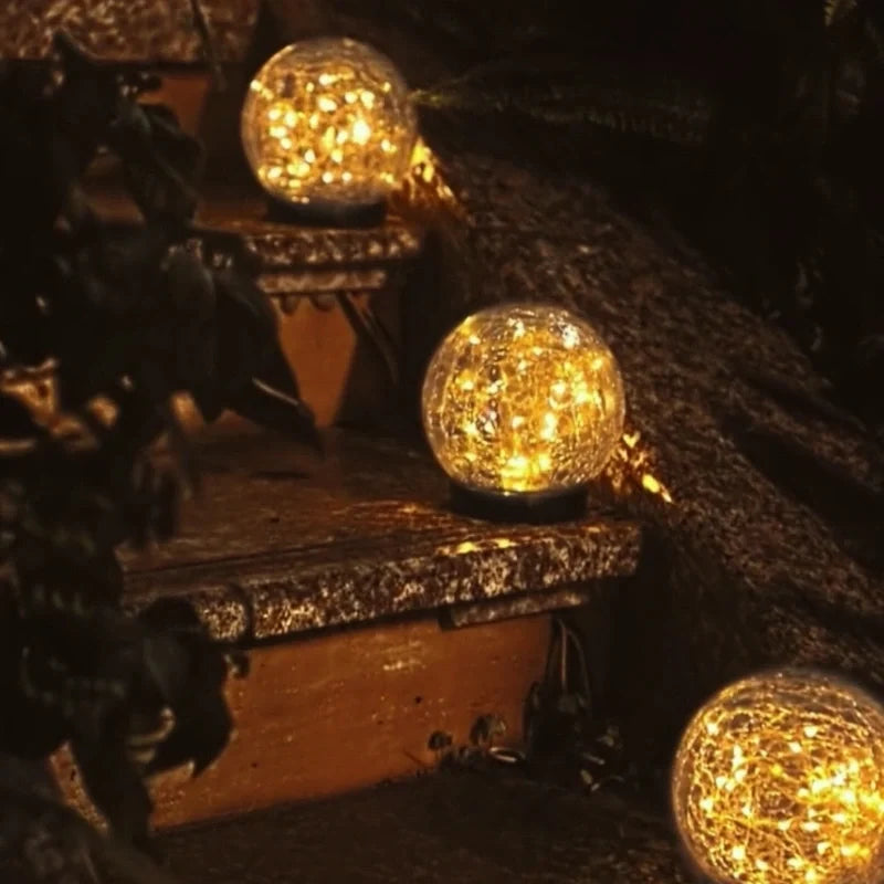 Three solar globes glowing on a dark stone ledge — Casa Norex