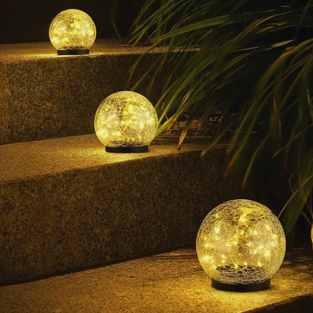 Solar globe lights placed on garden steps among foliage — Casa Norex