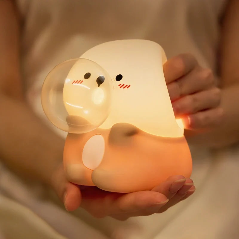 Squeezable silicone night light held in hands, glowing warm | Casa Norex