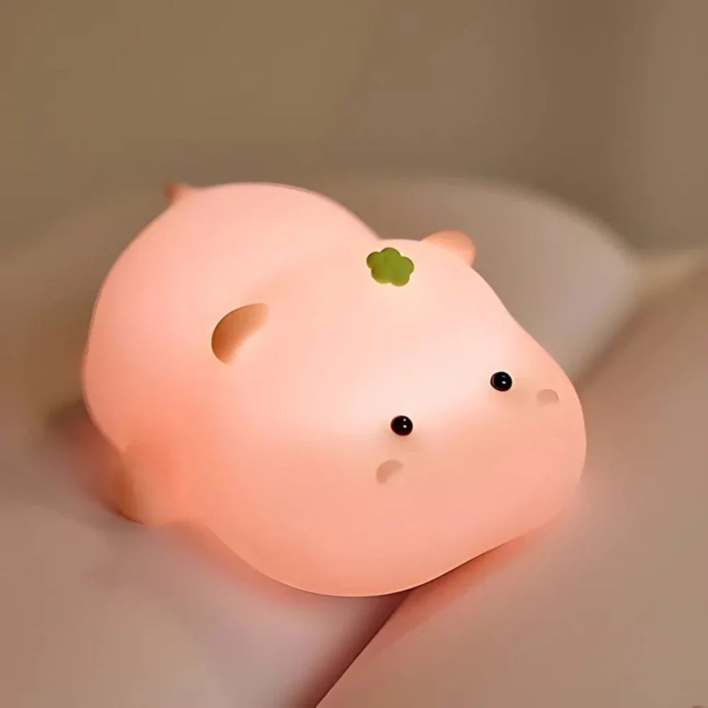 Pink Hippo Baby silicone night light on a bed — Casa Norex