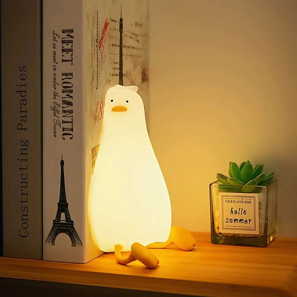 Tall duck night light glowing beside books on a desk — Casa Norex
