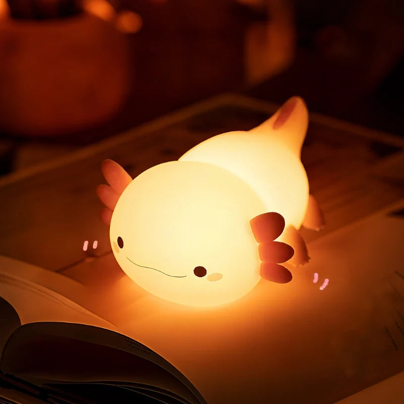 Axolotl silicone night light glowing on a dark table — Casa Norex