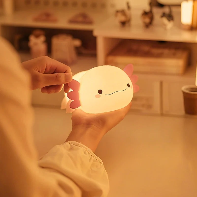 Hand holding a small white silicone night light — Casa Norex