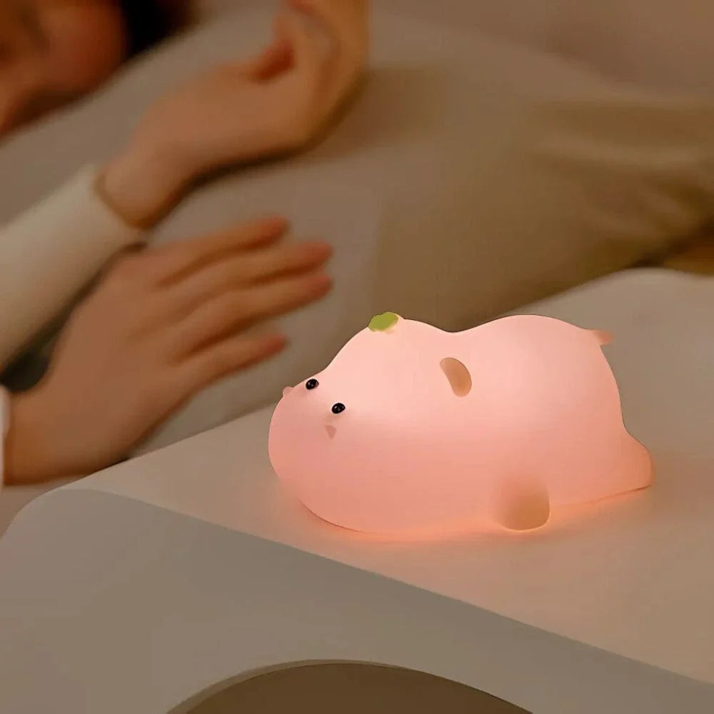 Hand beside a pink pig night light — Casa Norex