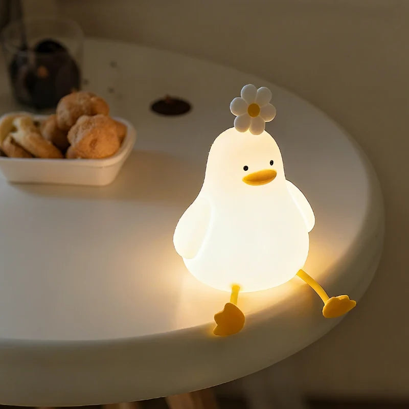 Duck night light glowing on a round table beside snacks — Casa Norex
