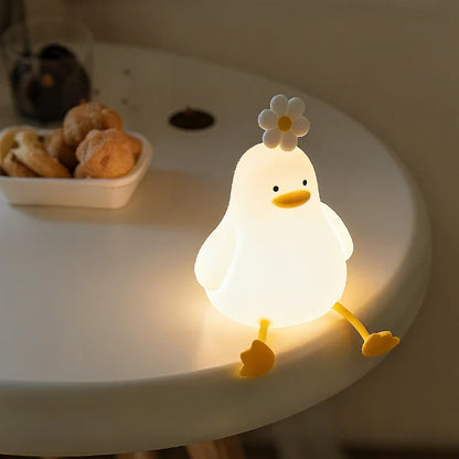 Duck night light glowing on a round table beside snacks — Casa Norex