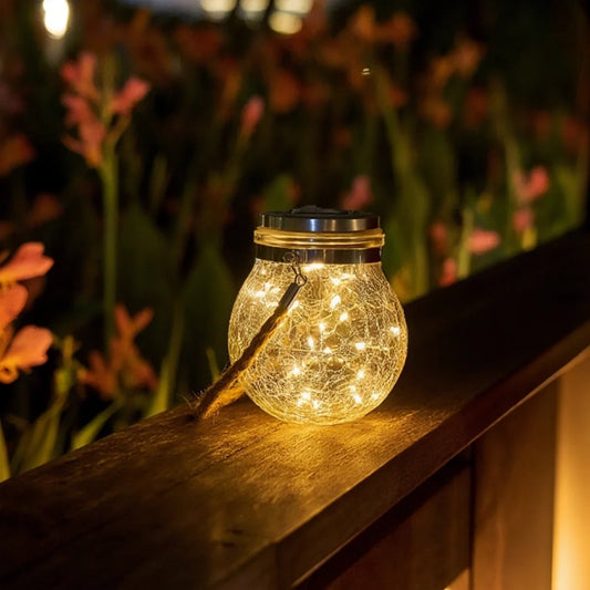 Large crackle glass lantern glowing on a wooden railing among flowers | Casa Norex