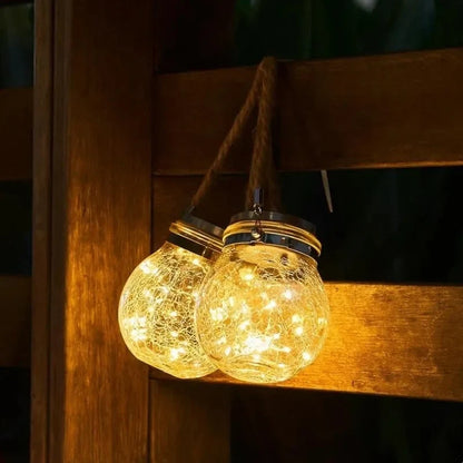 Two rope-handled glass lanterns glowing beside a wooden bench | Casa Norex