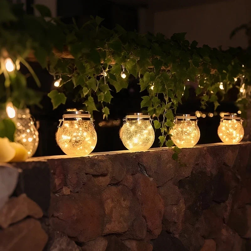Small lanterns glowing along a stone wall beneath fairy lights — Casa Norex
