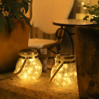 Two lanterns glowing on a patio floor beside a table — Casa Norex