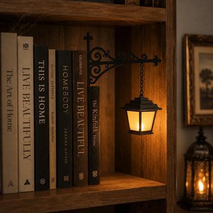 Black bracket of a bookshelf pendant light slid between books on a wooden shelf — Casa Norex