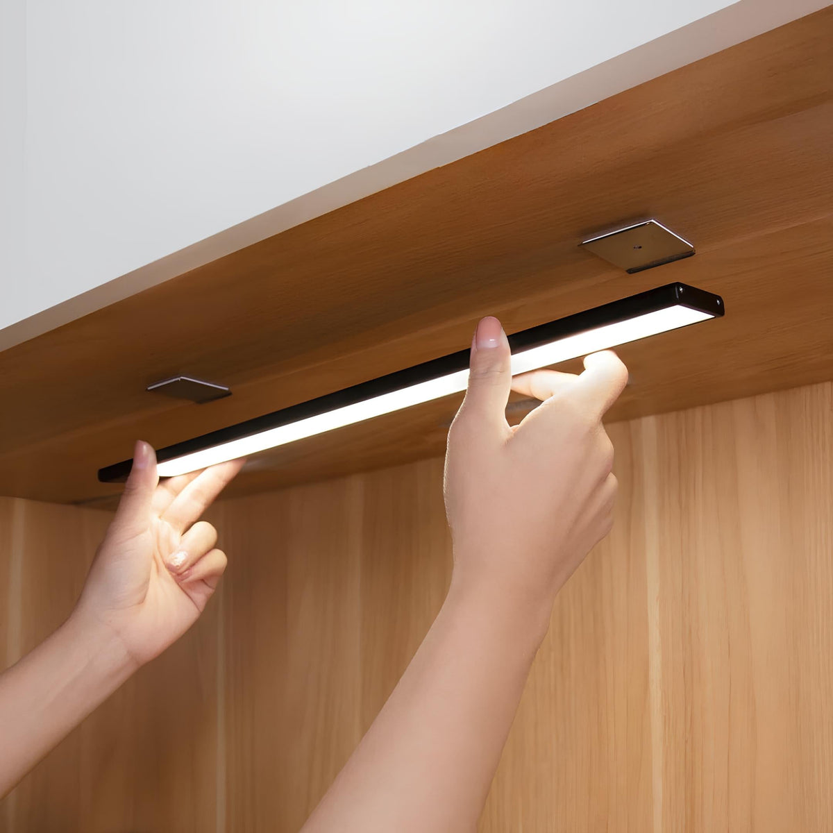 Hands attaching a light bar under a wooden shelf — Casa Norex