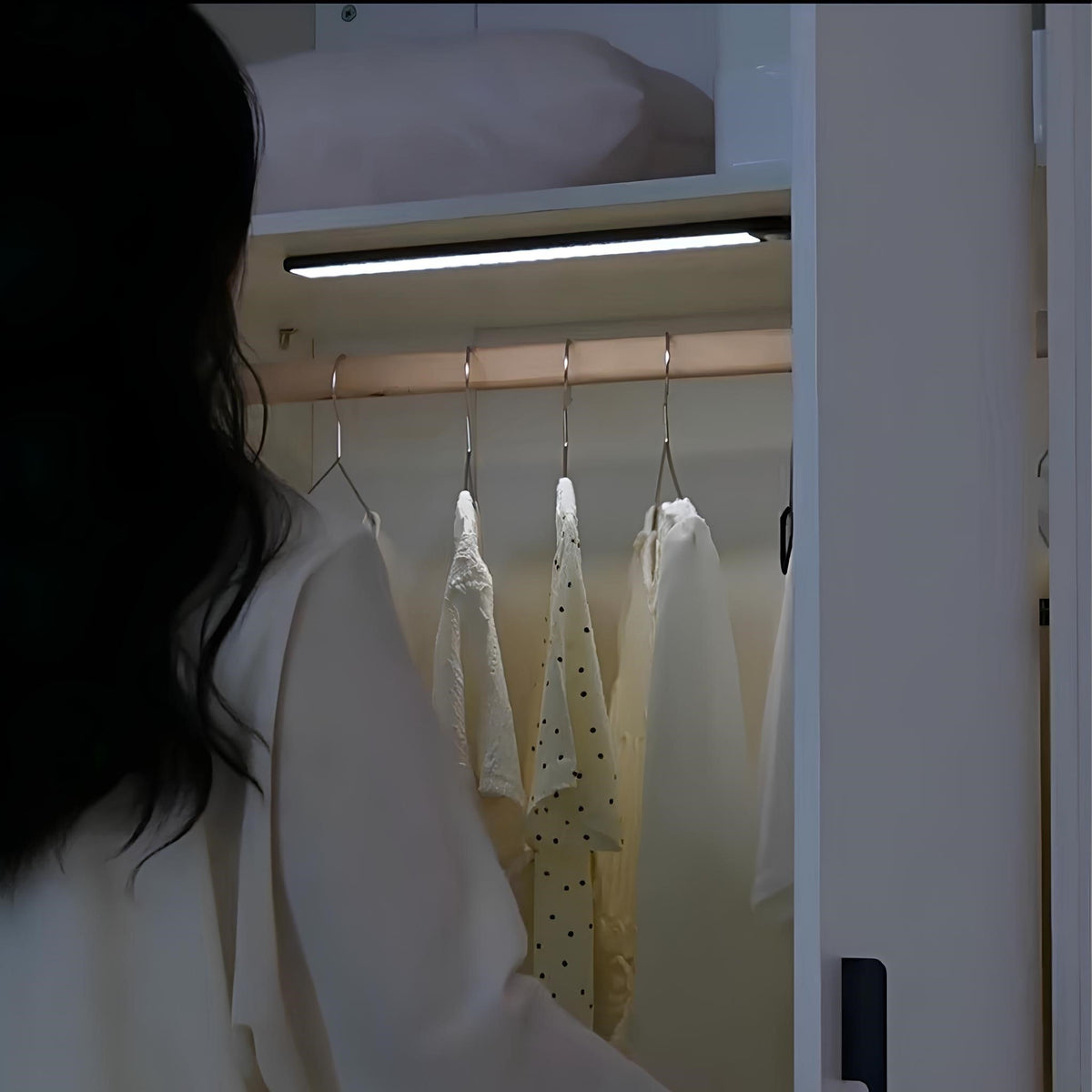 Person opening a wardrobe lit by a light bar — Casa Norex