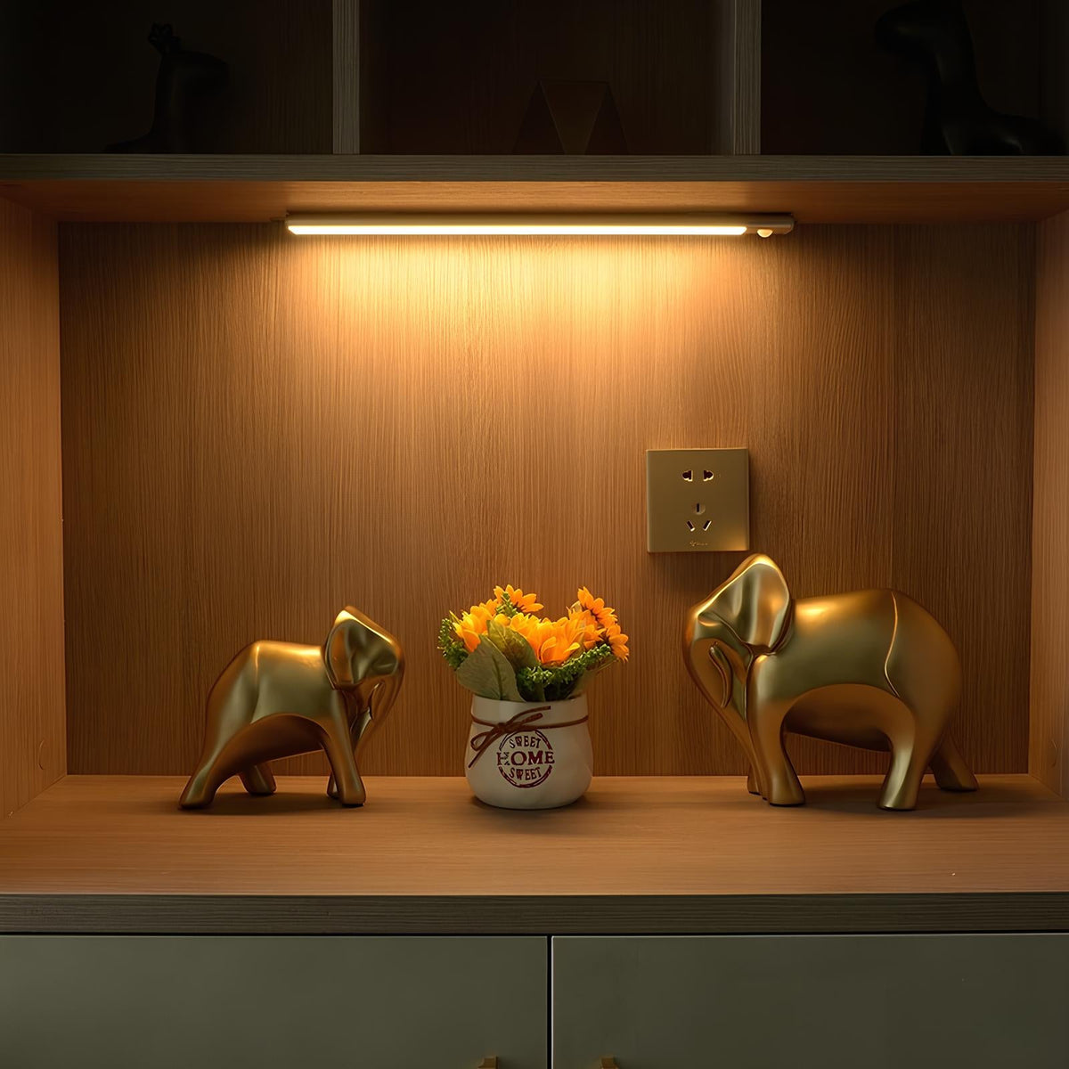 Light bar above small elephant ornaments and flowers on a shelf — Casa Norex