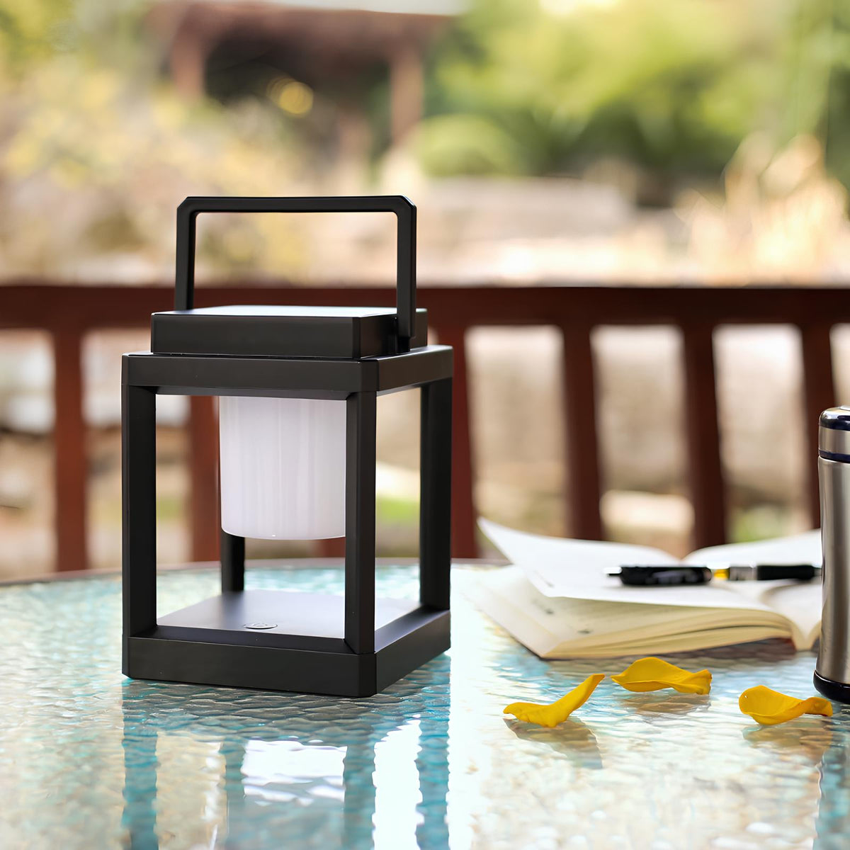 Solar lantern on a glass patio table beside a railing | Casa Norex