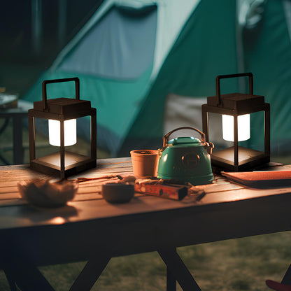 Two portable lanterns lighting a camping table beside a tent — Casa Norex