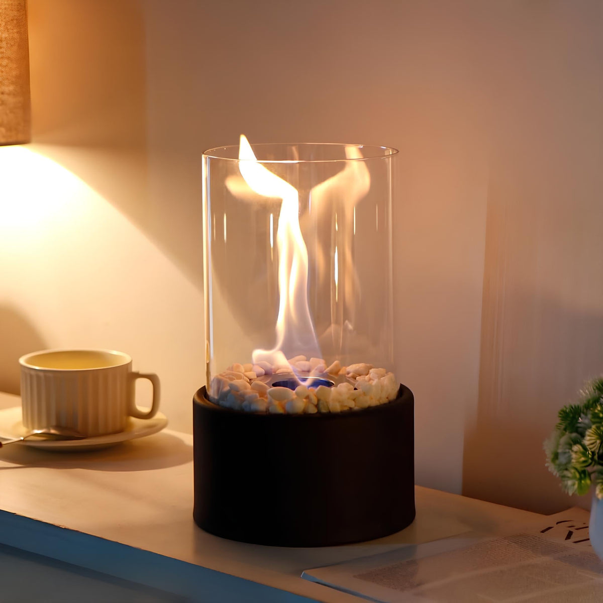Black oil lamp burning on a side table beside a mug and a lit lamp | Casa Norex