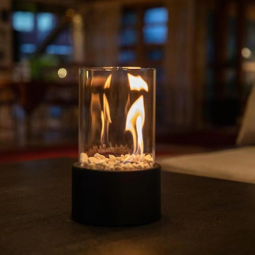 Black glass cylinder oil lamp glowing on a dark table at night — Casa Norex