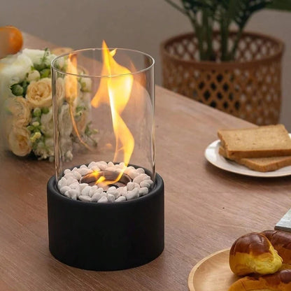Black oil lamp with a tall flame beside pastries and flowers on a table — Casa Norex