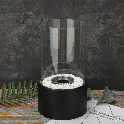 Black oil lamp on a dark patio surface surrounded by pebbles — Casa Norex