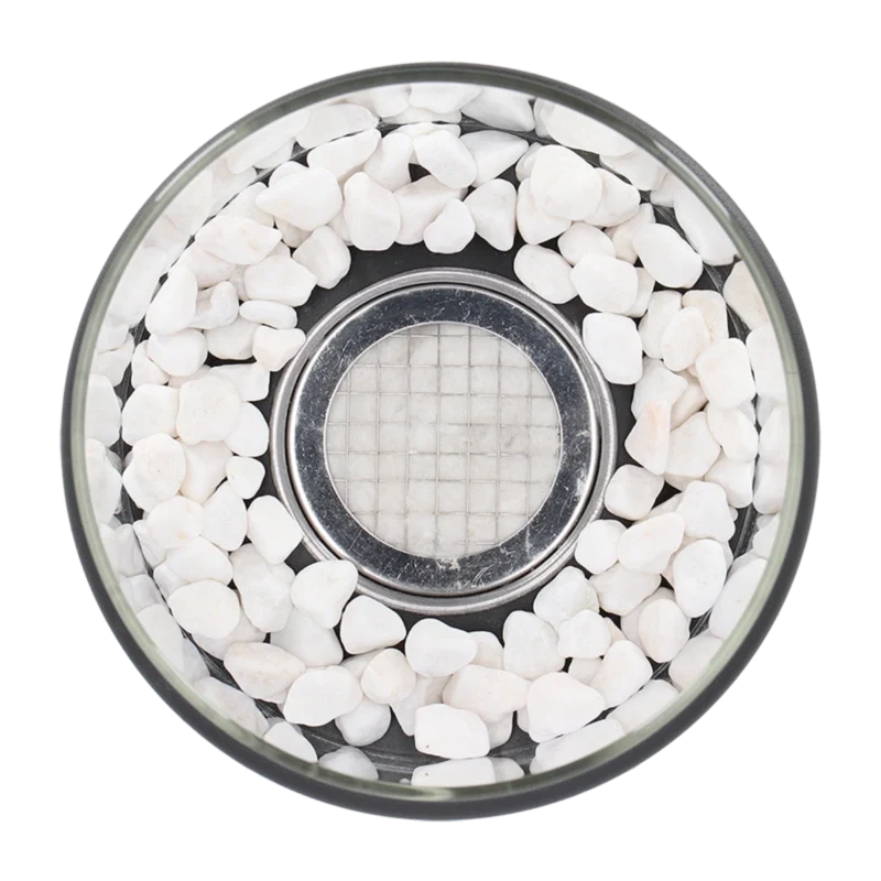 Top-down view of white decorative stones around the burner inside the glass — Casa Norex