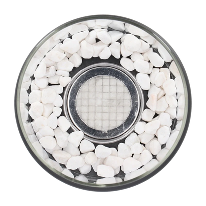 Top-down view of white decorative stones around the burner inside the glass — Casa Norex
