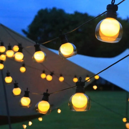 Warm white globe bulbs on a solar string hung beside a canopy | Casa Norex