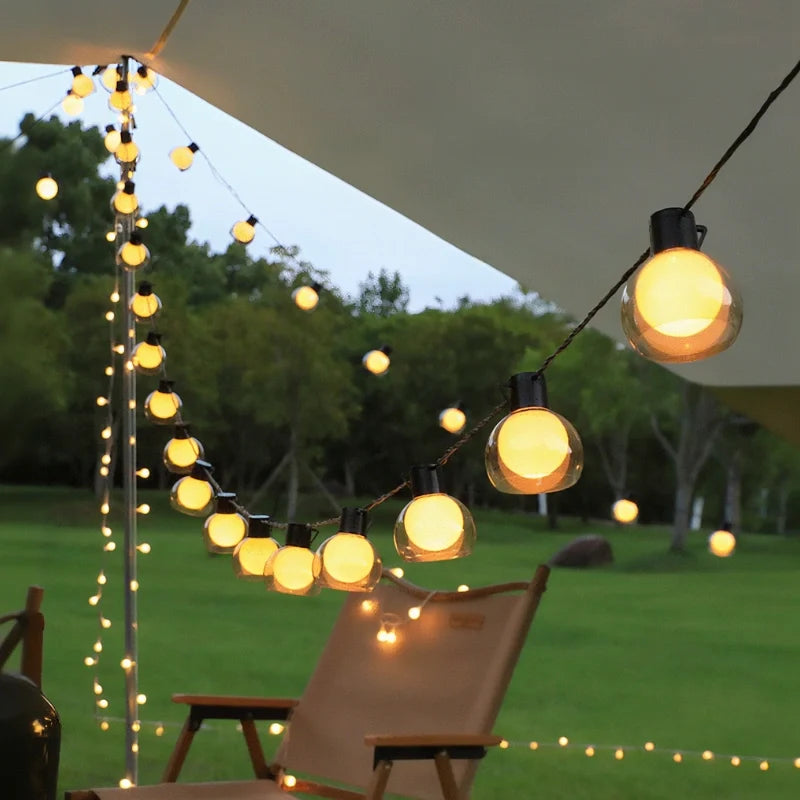 Solar globe string lights draped over a lawn with a lounge chair — Casa Norex