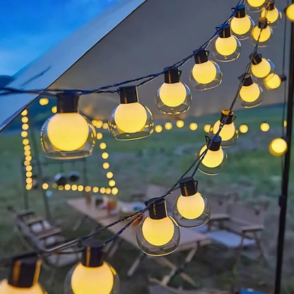 Solar globe string lights hung across a garden party space — Casa Norex