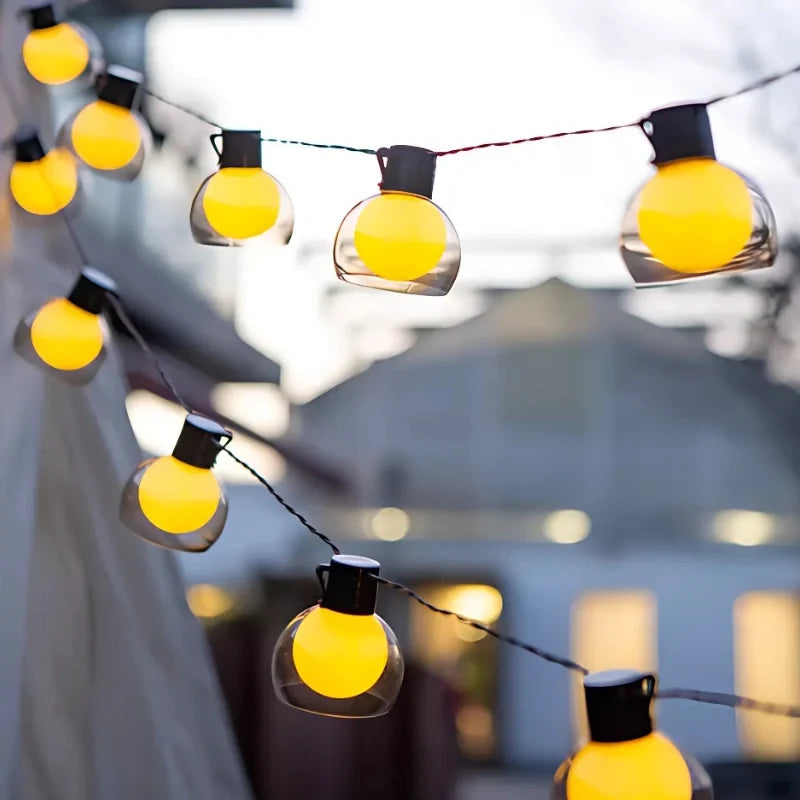 Close-up of globe bulbs on a solar string in daylight — Casa Norex