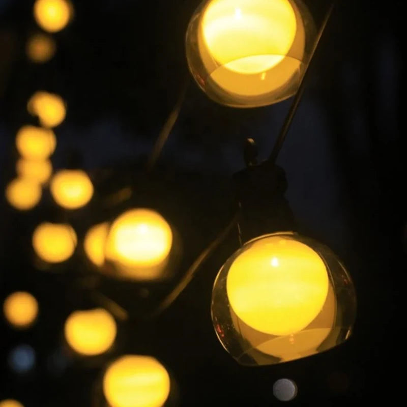 Close-up of glowing warm white globe bulbs on a string — Casa Norex
