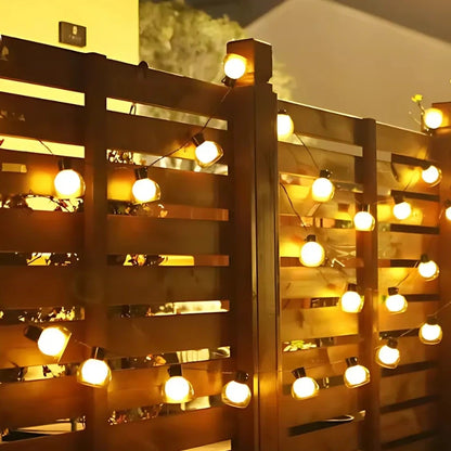 Solar string lights along a wooden fence at night — Casa Norex