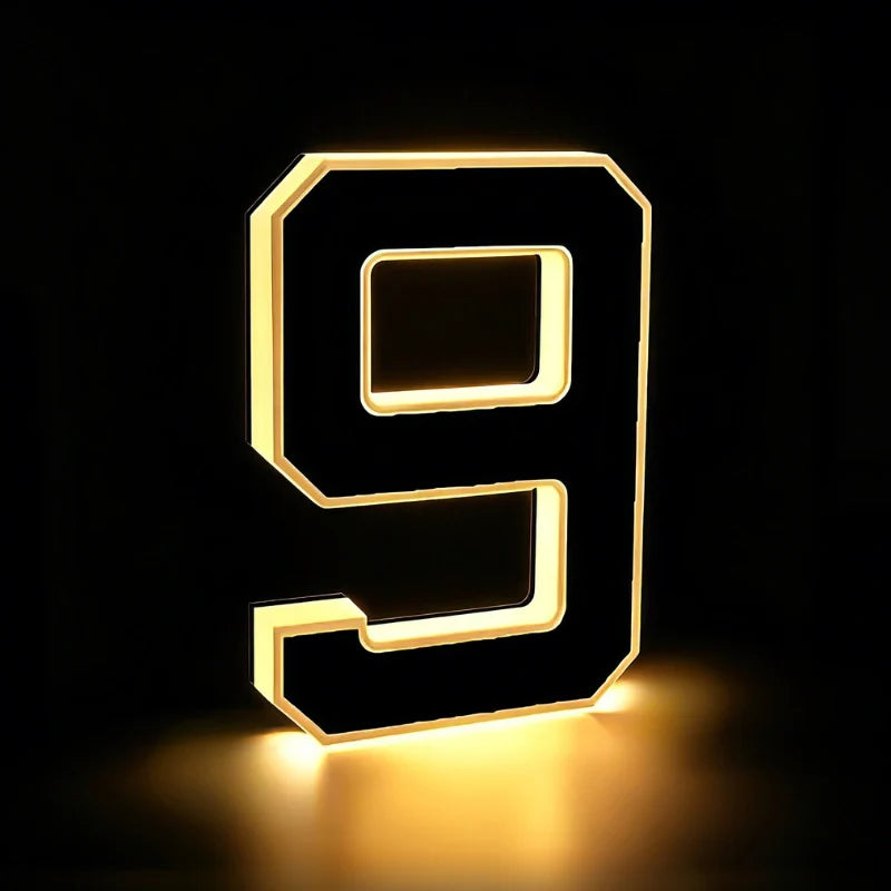 Illuminated number 9 glowing warm white on a dark background — Casa Norex