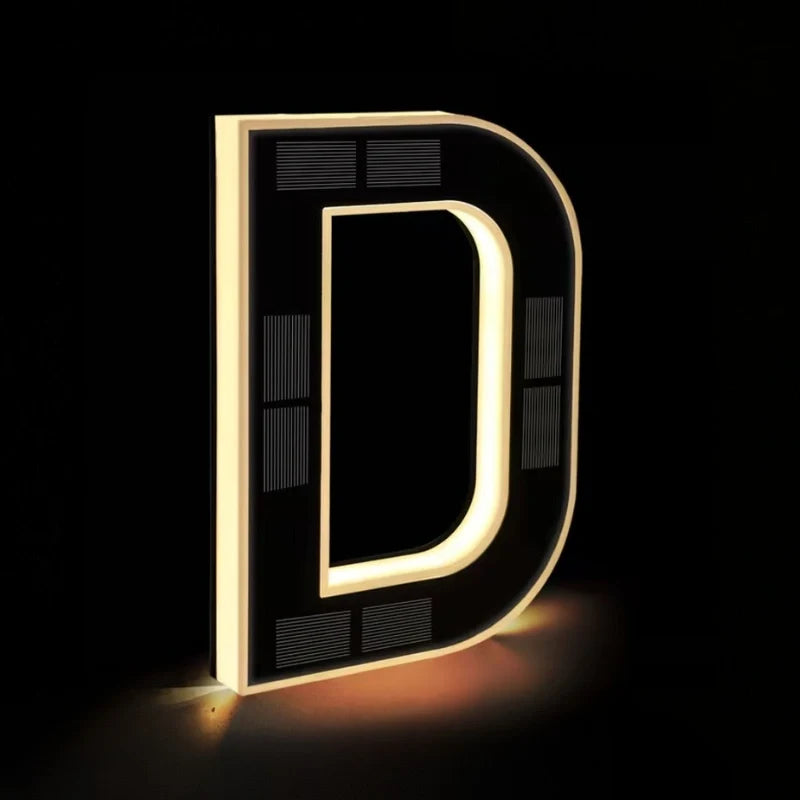 Illuminated letter D glowing warm white on a dark background — Casa Norex