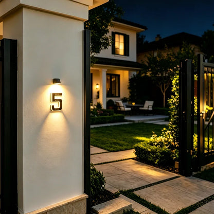 Illuminated number 5 on a wall beside a lit side entrance — Casa Norex