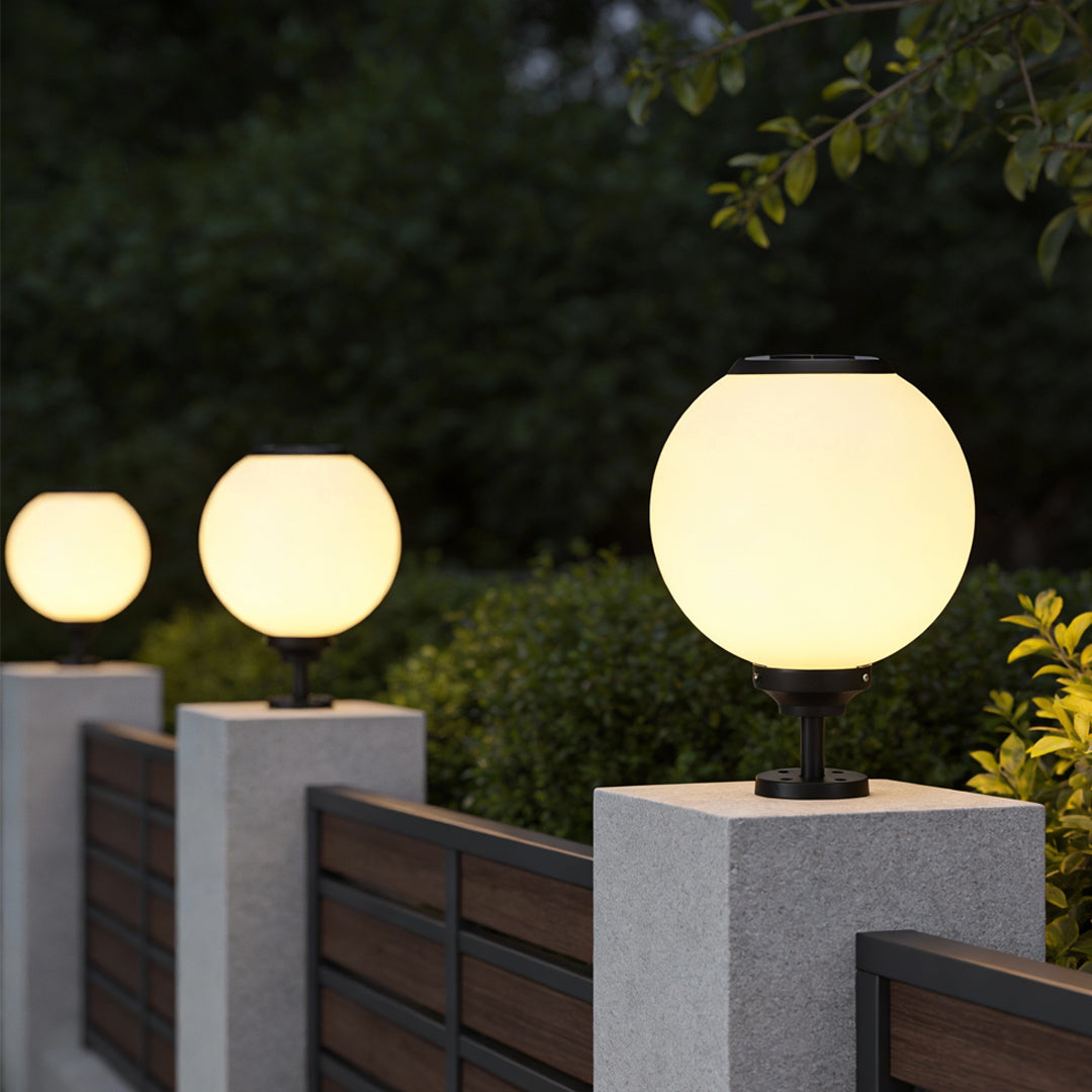 Orbit round solar outdoor pillar light beside a wooden fence